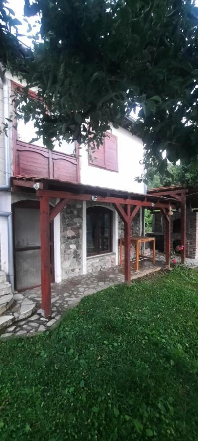 Side view of the house with its wooden veranda and lawn